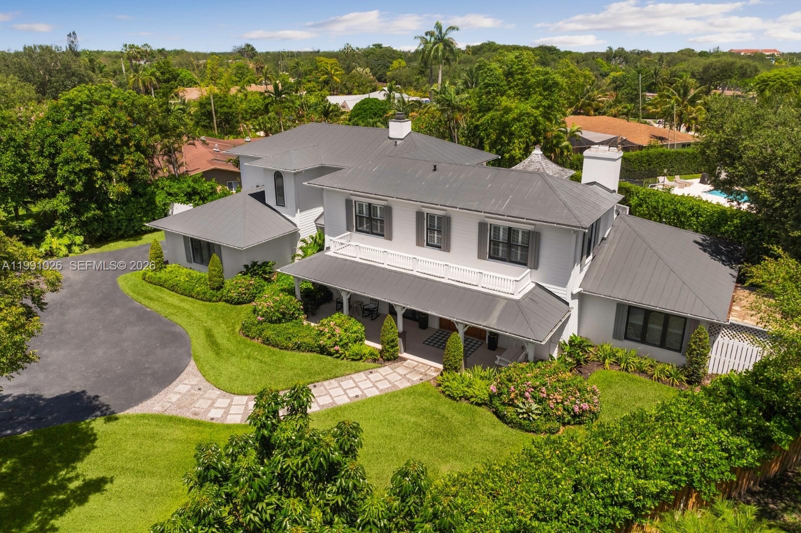 Modern farmhouse in North Palmetto Bay, set on a quiet tree-lined cul-de-sac. This 5BR/4BA home features vaulted ceilings, a split floor plan, and elegant porcelain and wood floors. The chef’s kitchen includes quartz countertops, a spacious island, premium appliances, and a 48” gas range. The primary suite offers a spa-like bath, walk-in closet, and private office. Outdoors, enjoy a fenced backyard with mature trees, gazebo, and pool surrounded by timeless Chicago brick—an inviting retreat for South Florida living.