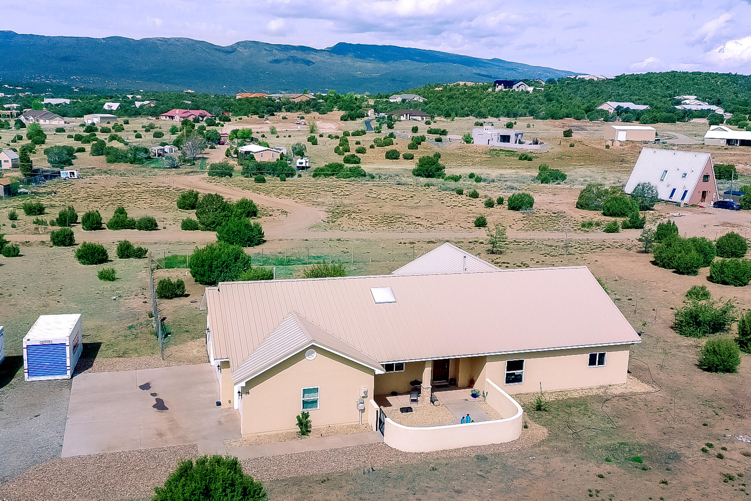 Custom home in Sandia Park NM on 2.36 acres w/ stunning Sandia Mountain views and no HOA! Open floor plan w/ cathedral ceilings, picture windows & wood plank tile flooring throughout (carpet only in primary). Kitchen features SS Dbl ovens, 5 burner cook top, microwave, dishwasher, walk-in pantry, island w/ breakfast bar, pendant lighting, skylights & granite counter tops. Living area incls pellet stove w/ stack stone hearth. Spacious primary suite offers a large walk-in closet, bathroom w/granite countertops, dbl sinks, jetted tub &walk-in custom tile shower. Expansive covered patio w/ ceiling fans and fenced section for pets. Addit features incl refrigerated AC, solid wood doors, community water, vinyl double-pane windows 843 sq. ft. oversized garage & water softener, RV parking.