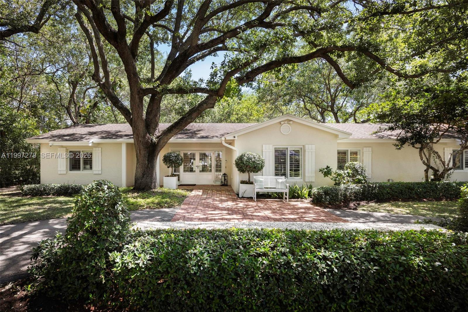 An exceptional corner property framed by eighteen oak trees, lush staghorn ferns, and a charming white picket fence that creates a storybook setting. Nestled in a highly desirable pocket of east Palmetto Bay just a few blocks from the bay, this 4-bedroom, 2.5-bath residence welcomes you with a formal foyer, warm wood floors, and French doors overlooking the pool. Imagine living in a neighborhood where neighbors become friends, with block parties, holiday gatherings, and pickleball games bringing the community together. Enjoy bike rides to the Old Cutler Trail, your morning coffee at Starbucks, and evenings exploring quaint local restaurants or catching concerts and breathtaking sunsets at the Deering Estate. A rare opportunity to experience the perfect blend of charm and community.