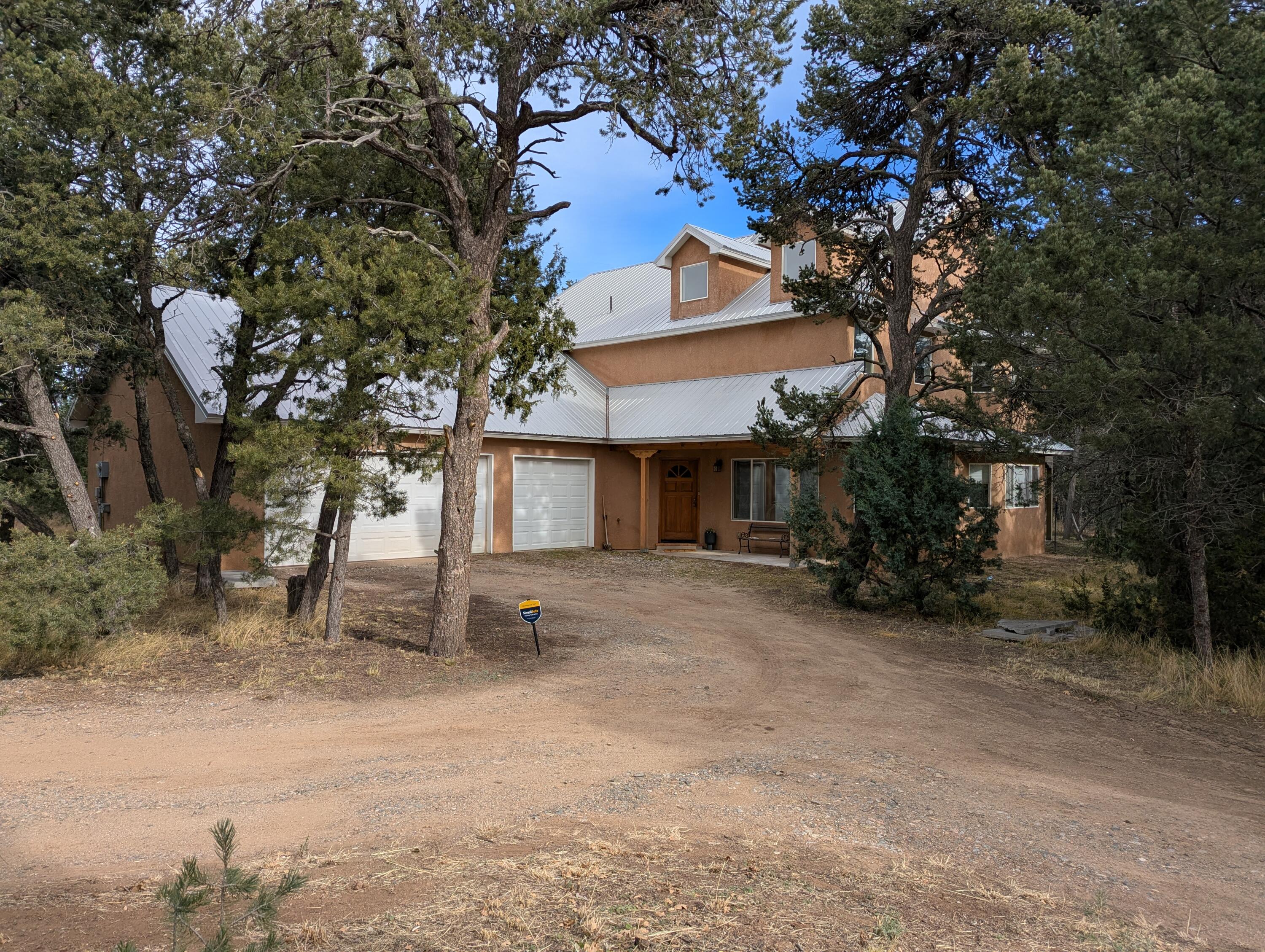 Equestrian-ready 4-bedroom home on 10 fully fenced acres in Tijeras, 40 minutes from Albuquerque and 25 minutes from Cedar Crest. The 2,500 sq ft two-story home features brick and oak floors, in-floor radiant heat, hot water baseboard upstairs, a high-efficiency fireplace, and a 3-car attached garage. Horse infrastructure includes a 36x36 barn with four 12x12 stalls, tack room, storage, and 12-ft covered overhang; an 18x30 hay/storage barn; and a 100x120 fenced arena in a wind-sheltered location. Productive well serves home and barn. Off SR 337 in a quiet rural community. An adjoining 78-acre parcel is available separately--See 14 Falling Star Drive.   MLS# 1101676