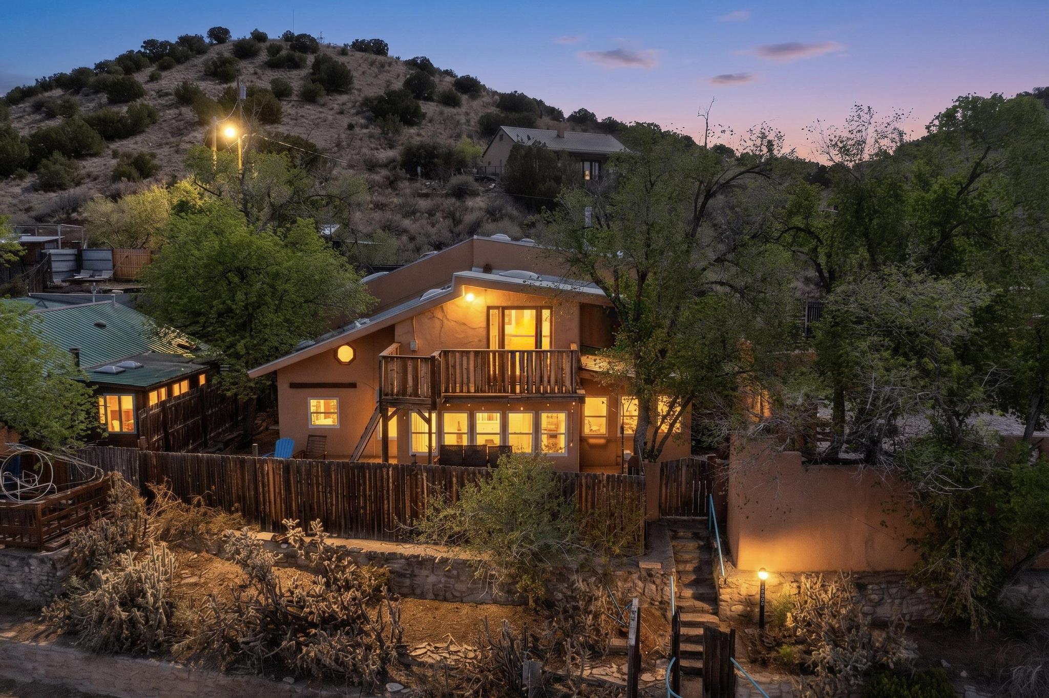 This stunning Madrid home is waiting for its artist, offering both residential and commercial potential on two side by side lots. The charming home sits up high off the main drag, right on the Turquoise Trail. The large deck out front offers great entertainment potential with wonderful views and lots of privacy. This home offers an open floorplan, including a large kitchen, a bedroom and office downstairs, and a large master suite with a walk in closet upstairs. There is plenty of natural light, as well as a whole home water filtration system, including reverse osmosis under the kitchen sink. The large side yard is tastefully landscaped and has a small outbuilding, perfect for an artist studio or gallery. Access and offstreet parking is available off of Ice House Rd.