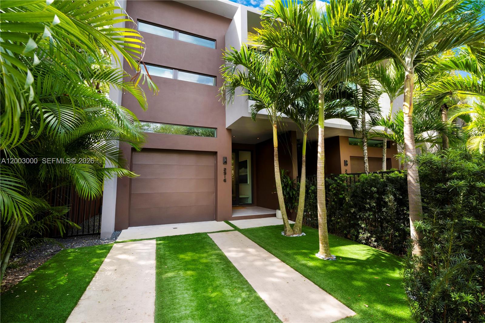 Discover modern luxury living in the heart of Coconut Grove. This thoughtfully designed home boasts an open, light-filled layout with high-end finishes throughout, creating an elegant yet inviting atmosphere perfect for everyday living and entertaining.The expansive main level features a spacious dining area or secondary sitting space, complemented by large windows and doors that flood the interior with natural light while ensuring peace and security. The show-stopping kitchen includes custom Italian cabinetry, a large waterfall island, and an attached custom table, crowned by a dramatic modern architectural light fixture. Premium appliances along with European plumbing fixtures, complete this chef-inspired space. Large-format porcelain flooring flows seamlessly throughout the main level, with wood tile upstairs.The family room impresses with a built-in Artefacto TV cabinet featuring custom wood slats and wallpaper accents, framed by custom linen curtains and motorized blinds for ultimate comfort and privacy. A dramatic modern glass stairwell adds architectural flair and connects the levels effortlessly.Upstairs, the large primary suite offers a luxurious en-suite bathroom with a double shower and custom closets. Two additional spacious bedrooms share a Jack-and-Jill bathroom, while the generous fourth bedroom includes its own en-suite and walk-in closet.