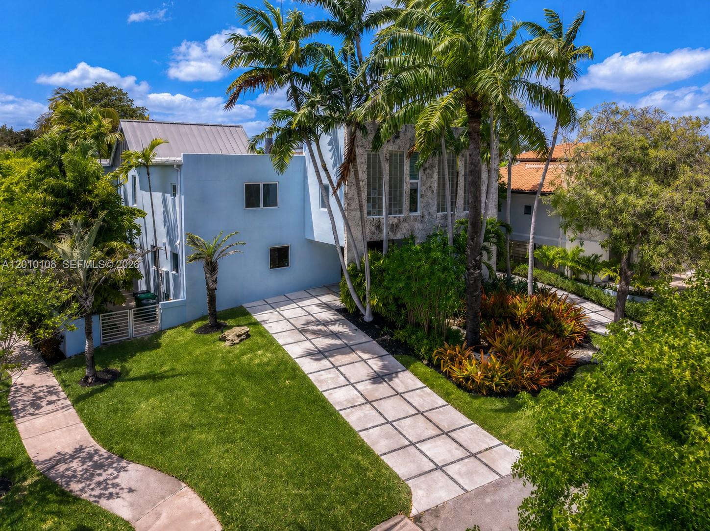 A truly exceptional Miami Modern Tropical residence set on a prime 8,010 SF corner lot, offering 3,549 SF of beautifully curated living space with 4 bedrooms and 3.5 bathrooms. Designed by architect Hervin Romney, a founding member of Arquitectonica, the home reflects a distinctive architectural vision inspired by the organic principles of Frank Lloyd Wright and the expressive forms of Antoni Gaudí, where art, design, and nature seamlessly converge. This residence captivates with its abundance of natural light, soaring high ceilings, fluid open spaces, and harmonious lines that create a sense of warmth, sophistication, and effortless flow throughout the main living areas.  The beautifully remodeled kitchen and bar are a true centerpiece, featuring high-end appliances, premium finishes, refined craftsmanship, and a design that balances functionality with striking aesthetics. Step outside into your own private tropical retreat, where lush landscaping, graceful curved terraces, and a stunning swimming pool create an atmosphere of tranquility and escape. This outdoor sanctuary is perfect for both relaxation and entertaining. As an added privilege, the property includes membership to the Key Biscayne Beach Club, offering exclusive access to one of Miami’s most coveted coastal lifestyles. Key Biscayne is renowned for its pristine beaches, charming restaurants, and vibrant yet relaxed atmosphere—delivering a true island lifestyle just minutes from the city.