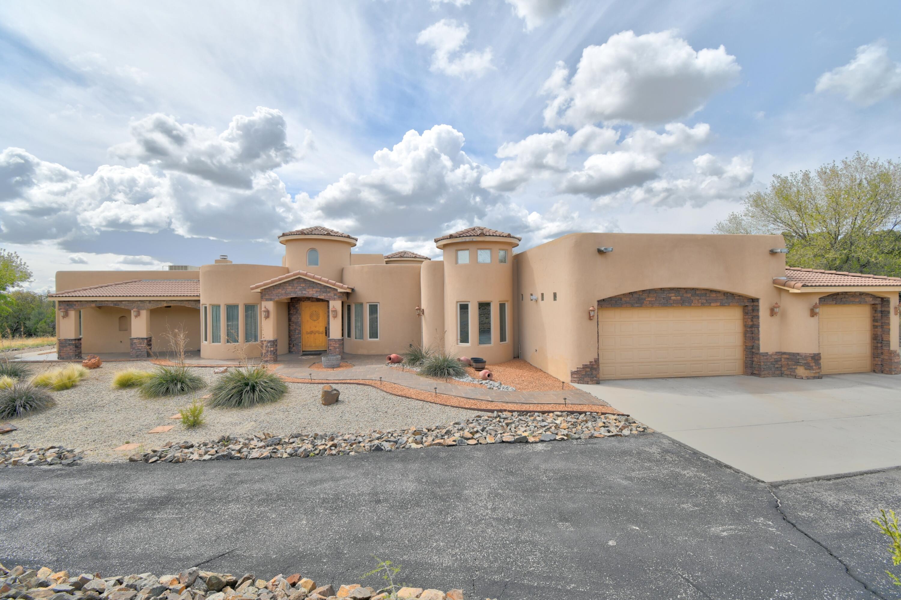 Escape the city life and settle into this luxurious Southwest-inspired Tuscan retreat in Sandia Mountain Ranch, where stunning views and peaceful surroundings set the tone. The light-filled great room features exposed wood beams, tile flooring, built-in shelving, and a cozy fireplace. The large kitchen is designed for gathering, offering granite countertops, a wraparound breakfast bar, eat-in area, and abundant cabinetry. A dedicated office/study with built-in bar adds flexibility for work or entertaining. The private master suite includes a kiva fireplace and spa-like bath. Each additional bedroom offers its own en-suite. The covered patio and 3-car garage complete this mountain escape, with more to discover.