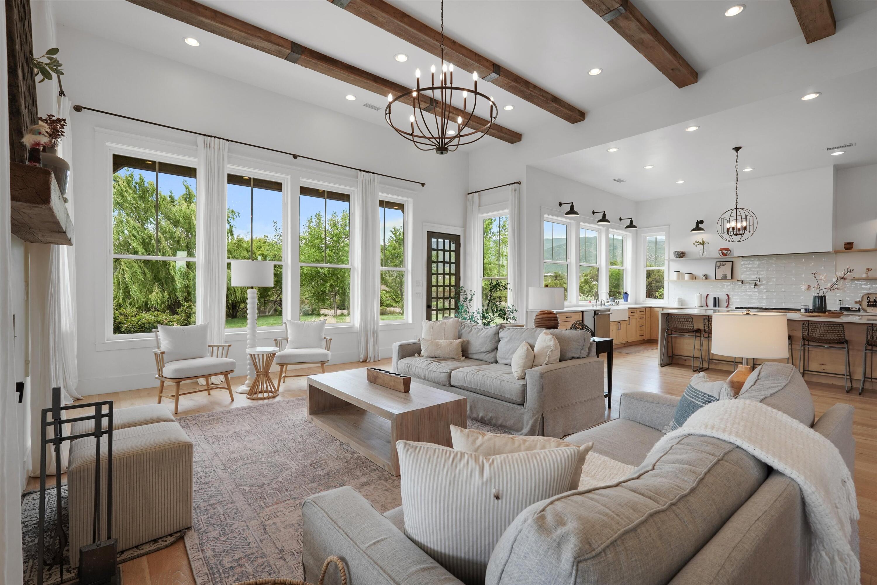 Extraordinary estate custom built and meticulously designed by its original owners -- a renowned builder and interior designer duo -- offering an exceptional blend of luxury, craftsmanship, and functionality. Situated on more than 10 pristine acres, the property delivers unmatched privacy, breathtaking panoramic views, and direct access to exceptional walking, hiking, biking, horse trails, and ancient native pottery shards, creating a true lifestyle retreat. Perfectly positioned to capture the surrounding scenery, the home is flooded with natural light through expansive windows that frame the landscape from nearly every room.  The grand great room showcases soaring 14-foot ceilings and an impressive open-concept design tailored for elevated entertaining and everyday living.At the heart of the home, the chef's kitchen features an oversized 12-foot island, a commanding 60-inch Thermador range, a fully appointed butler's pantry, custom cabinetry, and designer finishes throughout. Every detail has been thoughtfully curated, including white oak flooring, custom vanities, 8-foot doors, elevated ceiling heights, and an extensive list of premium upgrades that define the property's exceptional quality and timeless sophistication. The main residence spans approximately 4,650 square feet and offers 5 spacious bedrooms, 43/4 bathrooms, two distinct living areas, and an oversized 3-car garage complete with heating and air conditioning. Beyond the main home, the estate continues to impress with a beautifully appointed 2,500-square-foot barn featuring 4 horse stalls with a 1/4 acre corral, as well as a 1,200-square-foot heated and cooled RV garage complete with its own kitchen and bathroom -- ideal as a guest house, entertaining space, or private retreat. Designed for both recreation and relaxation, the grounds include a 60x120 riding arena, resort-style landscaping, tranquil pond and fountain, hot tub, mature fruit trees and fruit tree orchard, automatic sprinklers, full RV hookups, gated entry, and multiple covered porches that invite year-round indoor-outdoor living. A truly rare offering where luxury living, equestrian amenities, and uncompromising craftsmanship come together in one remarkable property.