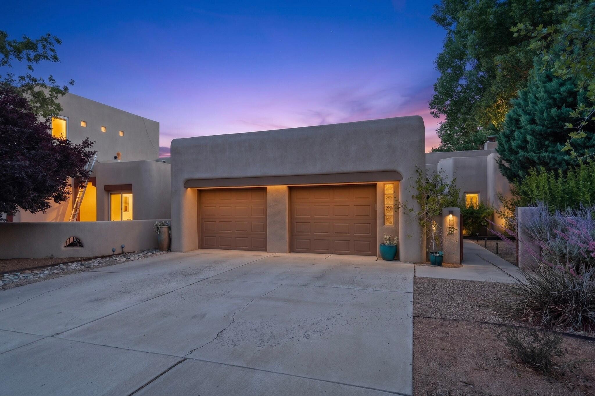 Tucked into the heart of Albuquerque, yet feeling worlds away, this Pueblo-style home sits in a private gated cottonwood neighborhood beside the acequia. Shaded by mature trees and surrounded by charm, the home offers that rare blend of peace, privacy, and city convenience.Start your morning with coffee in the courtyard garden, spend the afternoon wondering the Duranes Ditch, or head over to the Albuquerque BioPark, Old Town, nearby restaurants, museums, and trails. This location is almost unbelievable: tucked away, and still minutes from some of Albuquerque's best-loved destinations.The private courtyard creates a beautiful outdoor living space, perfect for flowers, evening conversations, and relaxing under the stars beside the outdoor fireplace.