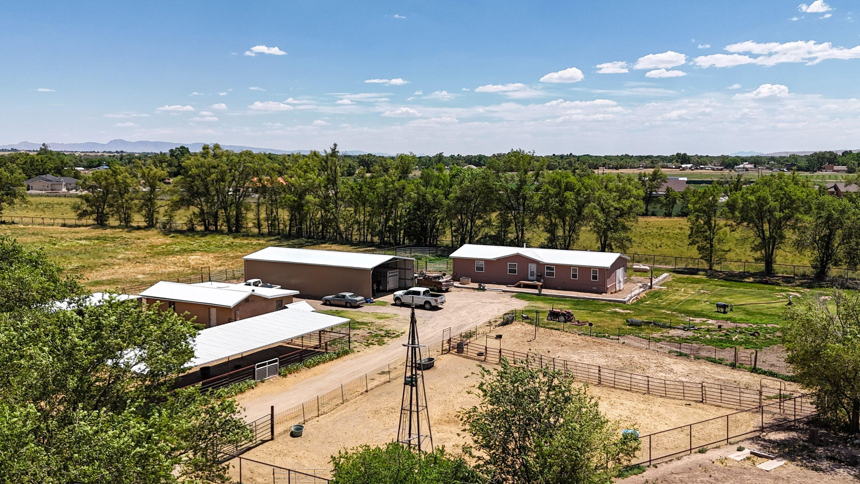 Versatile equestrian and agricultural property situated on 4.79 irrigated acres in Rio Communities near Belen, New Mexico. Offering space to live, work, and play, this unique property features a 3-bedroom, 2-bath Patriot manufactured home on a permanent foundation with approximately 1,848 square feet of comfortable living space. Including an open floor plan and large bedrooms with walk in closets. Designed for those who need room for livestock, equipment, hobbies, or a home-based business, the property includes approximately 4,200 square feet of metal barns and storage buildings. Improvements consist of an 1,800-square-foot open ended barn perfect for storing equipment, recreational vehicles, or trailers (hookups in close proximity).