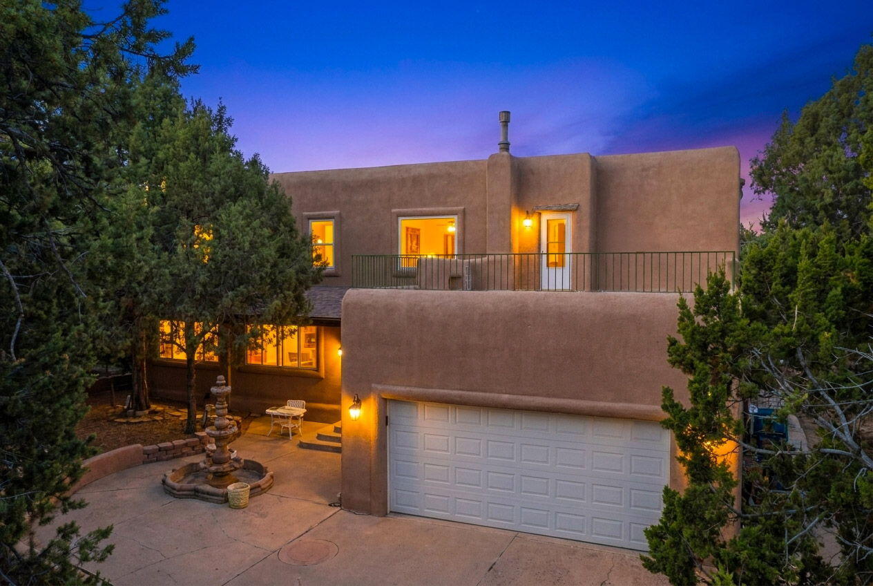 Discover this private 10-ACRE Southwest adobe estate in Tijeras! A gated private drive leads to a welcoming courtyard with a beautiful fountain in front of the charming stucco home nestled among mature pines. Enjoy sweeping forest and mountain views from the residence and spacious rooftop patio. Inside, an inviting open-concept kitchen with center island flows into elegant living and dining spaces, complemented by comfortable bedrooms and tastefully finished baths. Outdoor living shines with a tranquil pond, kiva-style fireplace, covered pavilion for entertaining, and multiple patios perfect for the high desert.  Plus a 30X50 backyard garage/shop! Ample room to expand or garden on this private parcel makes this secluded retreat ideal. A rare opportunity to own your own slice of paradise