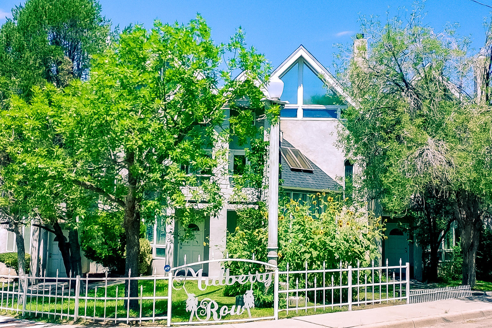 Rare Queen Anne-inspired townhome in desirable Spruce Park Mulberry Row w/NO HOA! Blocks to UNM, UNM Hospital & Presbyterian. 2 primary suites, 2 1/2 bathrooms, 2 car garage. Beautiful architectural details to incl. recently refinished orig reclaimed hardwood floors, stained-glass window, ornate cast iron wood burning FP mantel, travertine tile entry floors & cast Iron balustrades . New interior paint. Spacious Living room w/raised ceilings, Kitchen offers slate tile countertops, freestanding elec range & ample cabinetry. Each primary suite offers, full BA w/tile tub shower surround & private deck w/stairs to private courtyard on main level. Tons of natural light. New roof in 2013. Wood dbl-pane thermal windows, CFA gas heat, updated door hardware & landscaped front yard