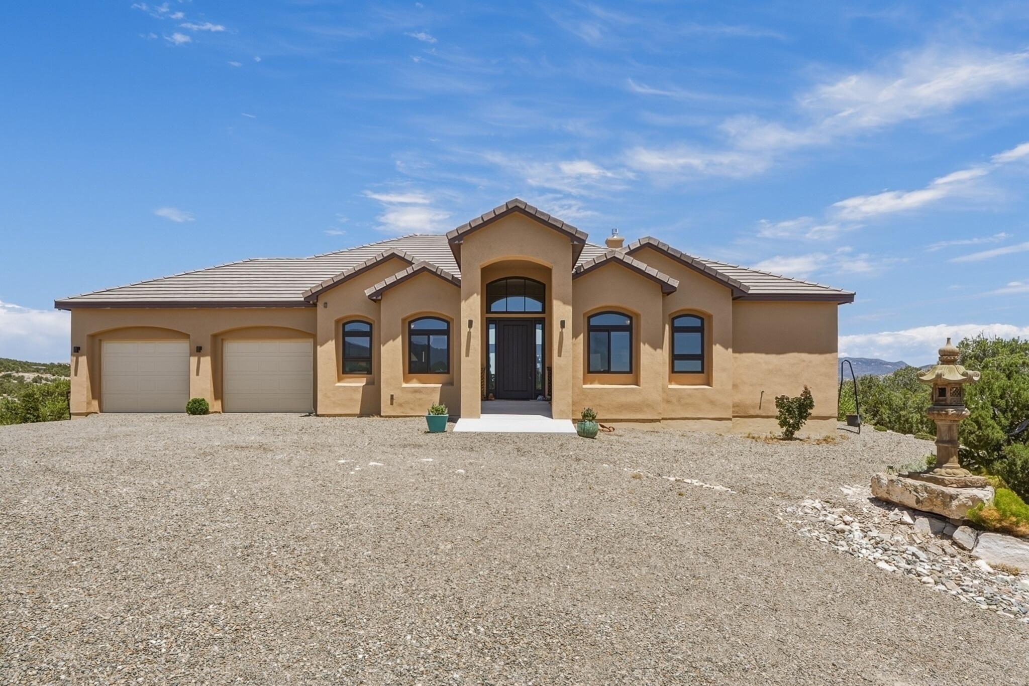 Experience an extraordinary lifestyle in the prestigious Paa-Ko community, where world-class golf, resort-style amenities, and the beauty of the East Mountains create one of New Mexico's most sought-after addresses. This exceptional custom home, just four years young, captures breathtaking 360-degree views and showcases the quality, craftsmanship, and attention to detail today's luxury buyer expects.A dramatic barrel-vaulted foyer opens to a spectacular great room with soaring beamed ceilings, walls of windows, and an expansive open floor plan filled with natural light. Two spacious view decks invite you to enjoy brilliant sunrises, unforgettable sunsets, and star-filled New Mexico skies, while the built-in hot tub and gas stub for outdoor grilling make entertaining effortless.