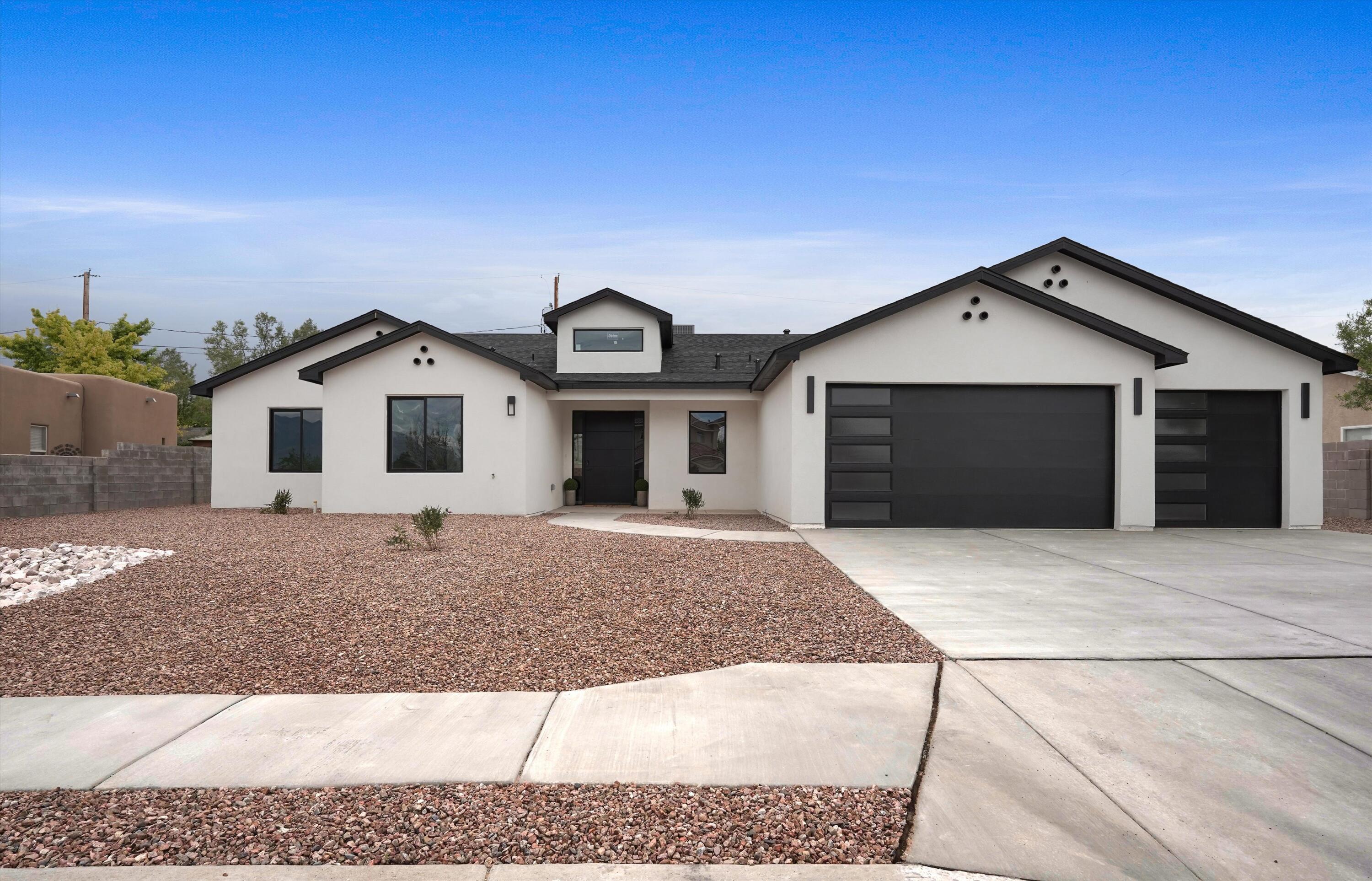 Prepare to be captivated by this spectacular, newly built custom estate offering the ultimate blend of high-end contemporary design and premium functionality. Situated on an expansive lot with meticulous low-maintenance desert landscaping, this 4-bedroom, 3.5-bathroom sanctuary makes a bold first impression with its crisp stucco finish, dramatic rooflines, and striking black accents.Step through the grand entryway into a bright, light-filled open layout boasting high-end modern finishes at every turn. The heart of the home is a chef's dream kitchen anchoring the main living space. Crafted for effortless entertaining, it features warm, natural-grain flat-panel wood cabinetry, a massive center island with breakfast bar seating, sleek dark stone countertops, and a matching solid-surface backsplash. The premium stainless steel suite is fully integrated, including built-in double wall ovens and a flush range with a matching wood-shrouded hood.The primary suite and guest bedrooms offer a true retreat with spa-quality bathrooms and designer tile work. Car enthusiasts, hobbyists, or travelers will marvel at the massive garage space, featuring an ultra-deep bay with extra-tall clearance--perfect for an RV, boat, or recreational vehicle storage. Experience a rare standard of turn-key modern luxury where no detail has been spared. The home offers a water softener preparation in the garage area, hot water recirculation and carrier combo package unit. Irrigation system