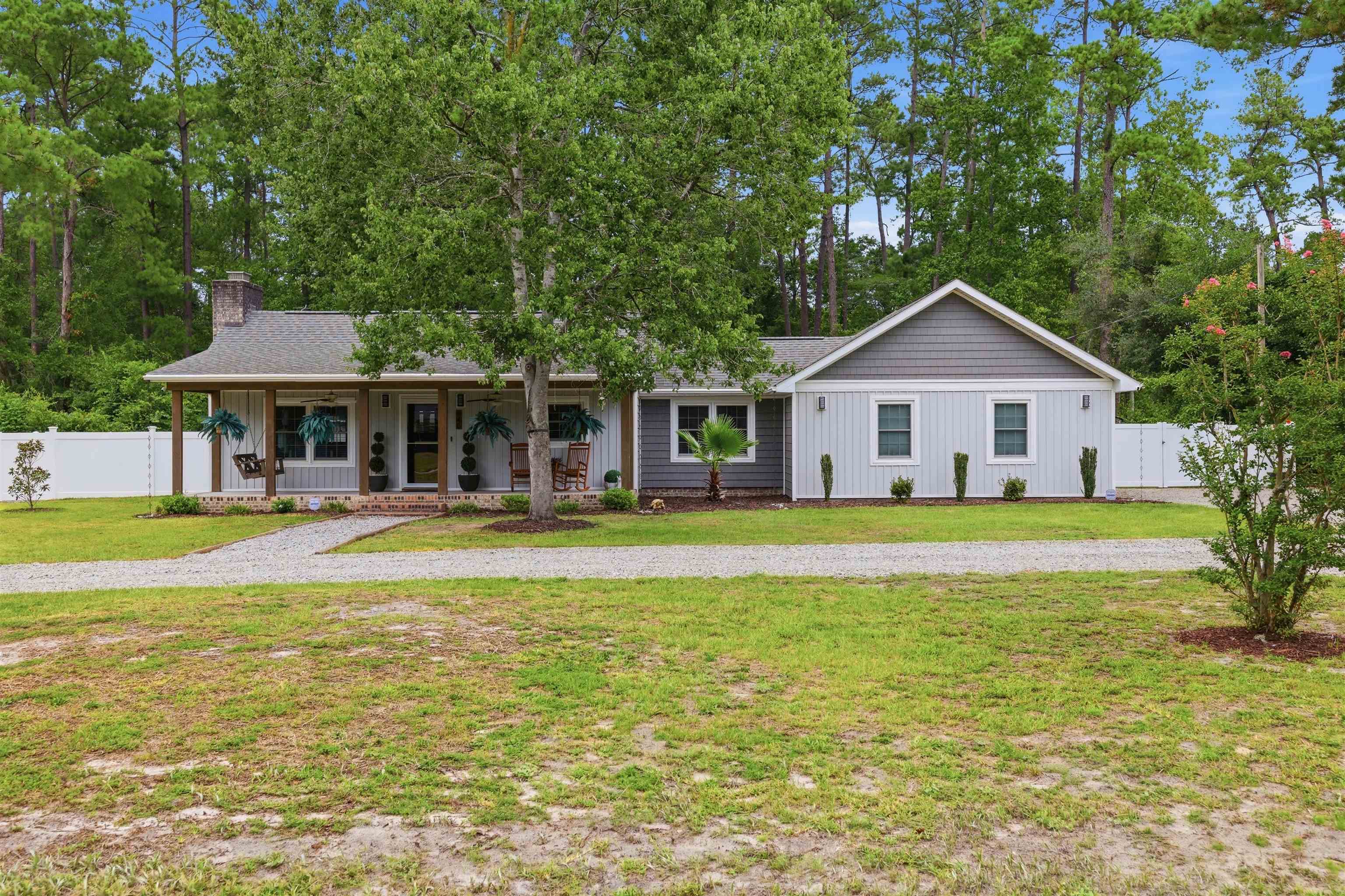 Two beautifully updated homes. One private acre. No HOA. Endless possibilities! This rare property offers a beautifully updated 2-bedroom, 2-bath main home with an attached 2-car garage plus a detached 2-bedroom, 1-bath guest home complete with its own kitchen, living room, laundry area, and private living space. Located just minutes from Coastal Carolina University, Conway Medical Center, shopping, dining, and Historic Downtown Conway, this property is ideal for multigenerational living, guests, a private home office, or income-producing rental opportunities. Extensively renovated inside and out, both homes feature new roofs (2021), new siding (2022), updated bathrooms (2025), Halo whole-house water filtration systems (2025), and numerous electrical updates (2025), providing peace of mind for years to come. The main home also boasts new luxury vinyl plank flooring (2021), a new HVAC system (2024), a completely remodeled kitchen (2025) with new cabinetry, butcher block countertops, tile backsplash, sink, bar, and brand-new appliances (2026), new trim throughout (2025), and a new water heater (2025). The detached guest home has also been tastefully updated with an updated kitchen (2026), new water heater (2026), and appliances (2021), making it completely move-in ready. Step outside to enjoy the beautifully landscaped grounds featuring a stone driveway, covered back patio, fenced backyard, and a relaxing saltwater hot tub. Two detached storage buildings convey, providing plenty of room for storage, hobbies, or workshop space. Whether you're looking for a primary residence with space for extended family, a property with excellent rental income potential, or a unique investment opportunity near Coastal Carolina University, this one checks every box. Properties combining a detached guest home, attached 2-car garage, extensive renovations, 1 acre of land, and no HOA are incredibly hard to find. Don't miss your opportunity to own one of the most versatile properties in the Conway area!