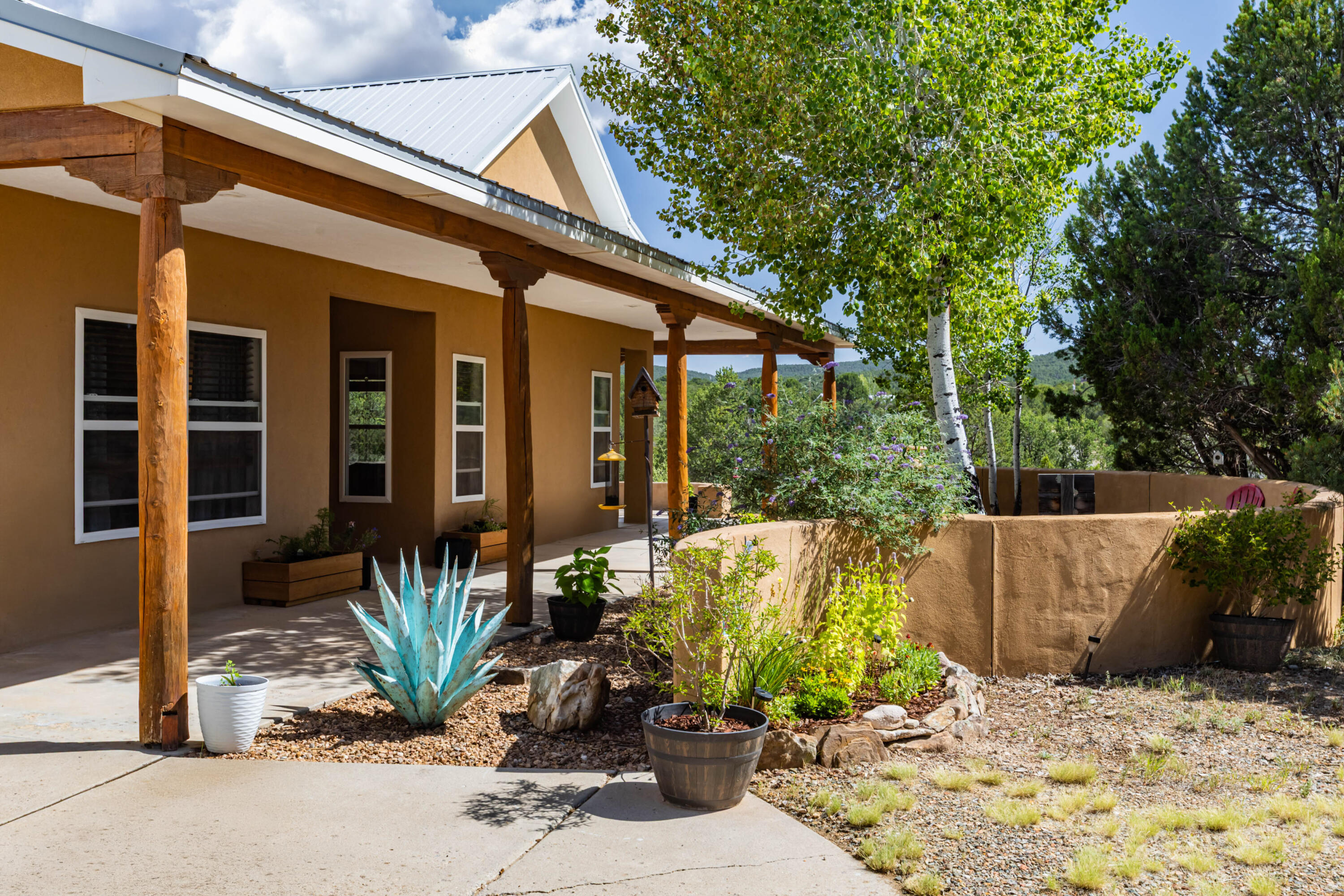 Gorgeous, tranquil and sublime Tijeras home with strikingly beautiful views at every angle!  Welcome to this single-level, accessible home including a roll-in shower in the Primary bathroom. This +5 acre getaway will knock you off your feet!  Seller-owned solar! Level 2 electric vehicle charger in garage!  Expansive kitchen with custom wooden cabinets, black soapstone countertops and spacious pantry.  Radiant heating throughout - including the garage!  Enjoy quiet mornings and superior sunsets on your wrap-around covered patios.  Gated entry for privacy.  This is the definition of East Mountain living...