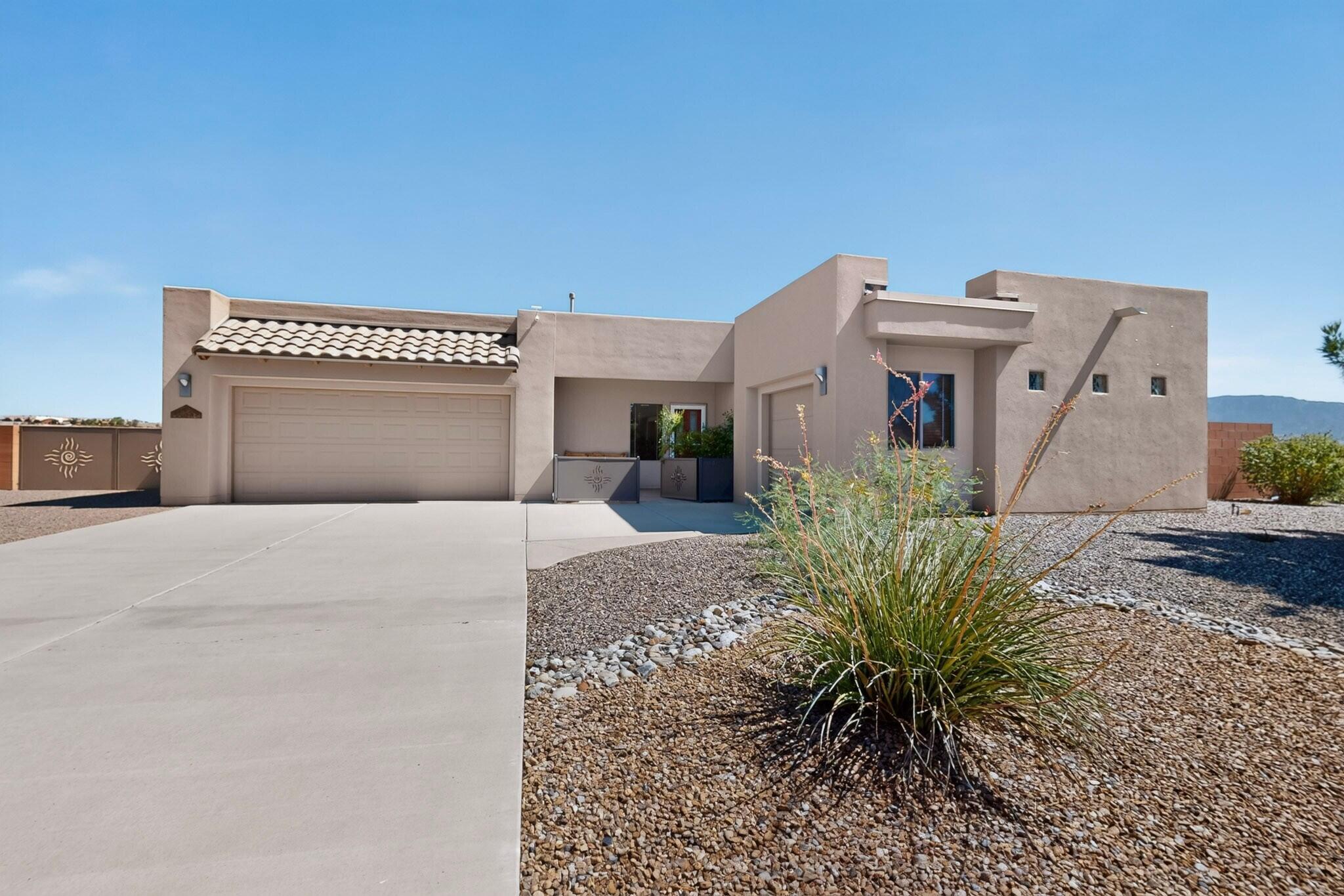 Situated on a gorgeous half-acre lot with no HOA and no PID, this beautiful Twilight Homes build is in pristine condition, with pride of ownership evident throughout. The home offers three bedrooms, two-and-a-half bathrooms, plus an office or study that could serve as a fourth bedroom. The highly functional split floor plan features an open-concept design with beautiful Sandia Mountain views from the kitchen, dining room, living room, and primary bedroom. The kitchen is a standout, showcasing granite countertops, extended cabinetry, a walk-in pantry, and an upgraded luxury KitchenAid backless gas range. Outside, custom decorative metal gates featuring Zia symbols provide backyard access and create a welcoming gated front courtyard space.  Additional highlights include a three-car finished garage, 18-by-18-inch tile, a gas fireplace, high-efficiency refrigerated air, central forced-air heating, and a built-in Taexx pest-control system. The garage offers flexible space for a workshop, home gym, hobbies, or extra storage. Beautifully landscaped front and back yards are complete with colorful flowers, mature trees, and incredible mountain views!