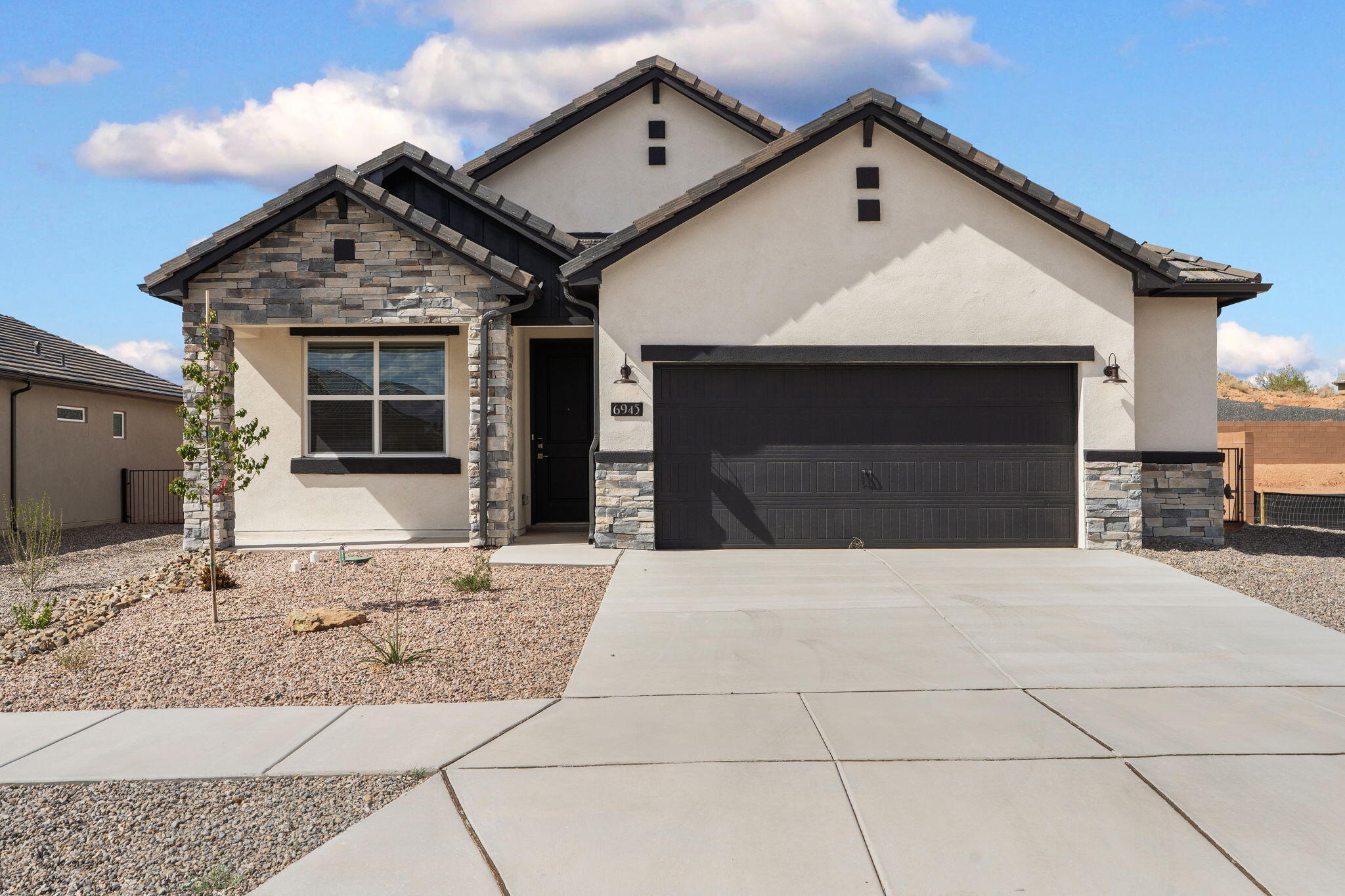 Single-Story Elegance in Lomas Encantadas: Welcome to the San Juan Plan 1,651 Sq. Ft. | 3 Bed | 2.5 Bath | Oversized 2-Car Garage | Elevation C Located in the master-planned community of Lomas Encantadas in Rio Rancho, this single-story home delivers high-performance living certified NM Build Green Gold for energy efficiency. Showcasing the striking Elevation C facade enhanced with architectural stone accents, the home welcomes you into an airy 9-foot ceiling layout styled in the timeless, warm Sandstone palette with classic brushed nickel hardware, fixtures, and 2' faux white wood blinds throughout. Rich Pecan colored cabinetry pairs with Kashmere Cream granite countertops and a Ivory tile backsplash in the open kitchen, centered around an eat-in island, stainless steel appliances, a large walk-in pantry, and a 30' stainless steel farmhouse apron sink. Low-maintenance tile extends through all main living and wet areas, with plush tan carpeting adding comfort to all three bedrooms. The private owner's suite features an expansive walk-in closet and ensuite bath, while secondary bedrooms offer ideal space for family, guests, or a dedicated home office. Storage and utility are maximized with a powder bath, dedicated laundry room, and an oversized 2-car garage. Step out to the covered back patio to enjoy outdoor living near neighborhood walking trails, local shopping, and dining. Home is ready for it's new owner. Call today for you exclusive tour.