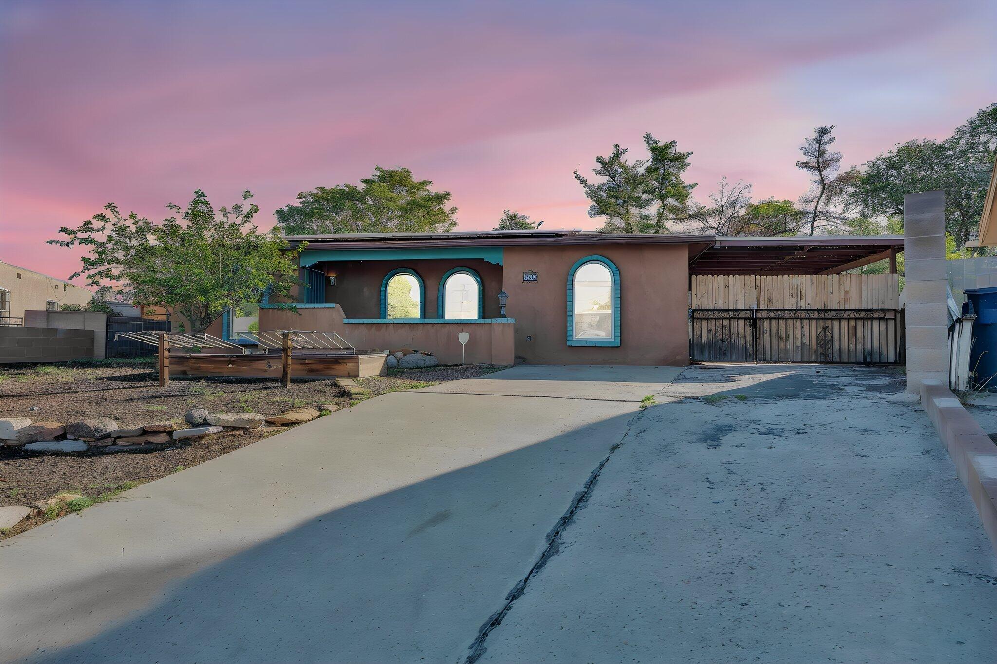 You're going to love this charming East Downtown artist's abode at the end of a cul de sac!The character oozes from every corner, from the warm Saltillo tile flooring to the wooden accents in the gourmet kitchen, to the splashes of color throughout the home's well-designed layout. Double doors to the covered carport off the dining room provide perfect indoor-outdoor living for Albuquerque's year-round friendly weather.The creative energy this home exudes is apparent from the murals along the back yard walls to each of the bedrooms' distinct personalities.The primary suite features a gigantic walk-in closet and en-suite bathroom many will crave.From the owned solar panels keeping your electricity bills under control, to the oversized city lot offered by the cul-de-sac it is located in, to the central location in the heart of the city with enviable seclusion, this home truly has it all.Relax in the hot tub at the end of the day, and enjoy the serenity and tranquility embracing you at the end of the road quite literally named for the peace you'll experience here.