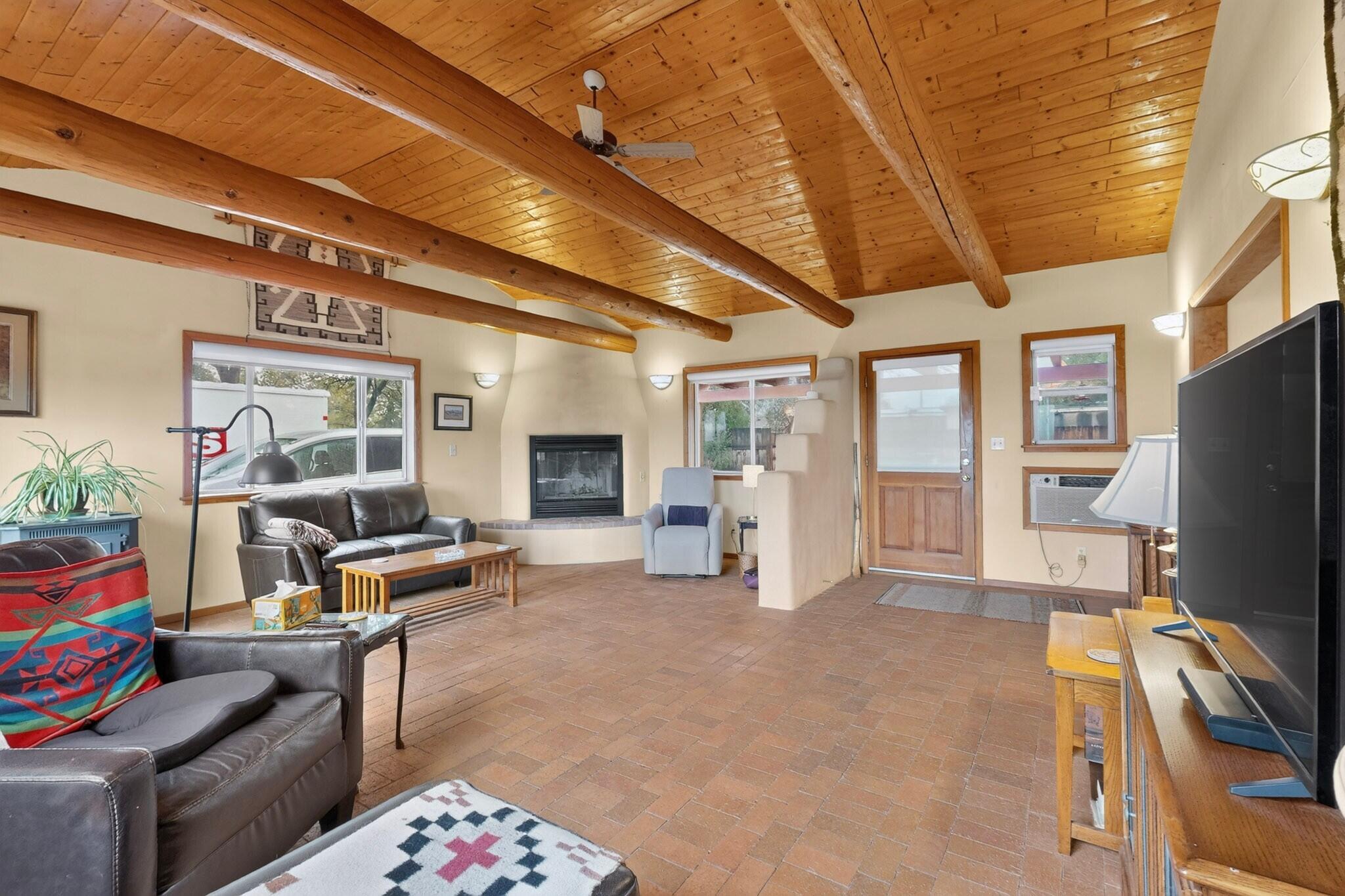 Custom built home on the south side of Bernalillo just one lot off of the Sandia Pueblo Reservation. This is a lush half acre with mature landscaping and private fencing all around. Original home has been added onto with a living room, kitchen and formal dining room and many upgrades over the years. The 3 BR, 2 BA house has a charming great room with vaulted tongue and groove ceiling, vigas, kiva fireplace and brick floors. The kitchen has granite tile, oak cabinets and brick floors. Updates include both bathrooms, metal roof, propane wall heaters, and refrigerated window units. Detached 12x16 studio/workshop, wood barn style oversized one car garage, planting areas, large cottonwoods, private patio and storage shed included on the lot. On city water, with septic system and propane gas ( natural gas is stubbed out at the house). Great view of the Sandias, across from main ditch and peaceful quiet at the end of the road.
