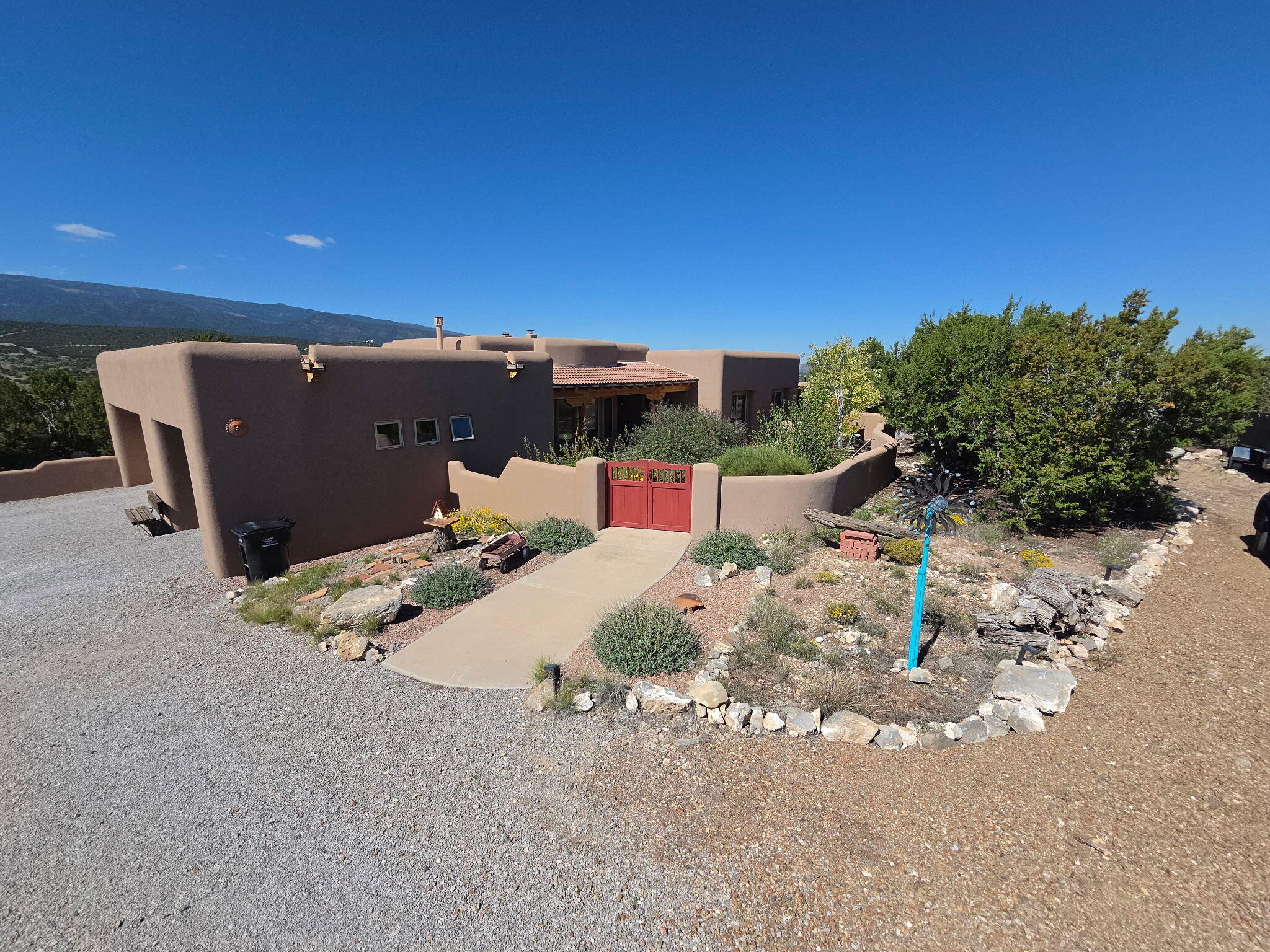 Enjoy the tranquility and natural beauty of Sandia Park from this Southwestern-style Pueblo home situated on 10 private acres with beautiful Sandia Mountain views. The inviting covered courtyard opens to a spacious great room featuring beamed ceilings, wood accents, and a cozy great room kiva fireplace.. The well-designed single-level floor plan offers 3 bedrooms, a separate office, an additional kiva fireplace in the mstr bdrm that has a exterior door to a covered patio with hottubconnections, and custom upgraded cabinetry in the kitchen and bathrooms. Other features include three-car garage, storage shed/playhouse, dog run and ample acreage for enjoying the peaceful setting. Recent improvements include new carpet and interior paint, a new water softener, reverse osmosis system, and whole-house water filtration system. Motorized blinds have been added to the dining room and all living room windows. A new graveled parking area has also been added, providing additional convenient parking. These improvements enhance the functionality, comfort, and presentation of the property. A distinctive San Pedro Creek Estates property offering privacy, space, Southwestern character, and mountain views.