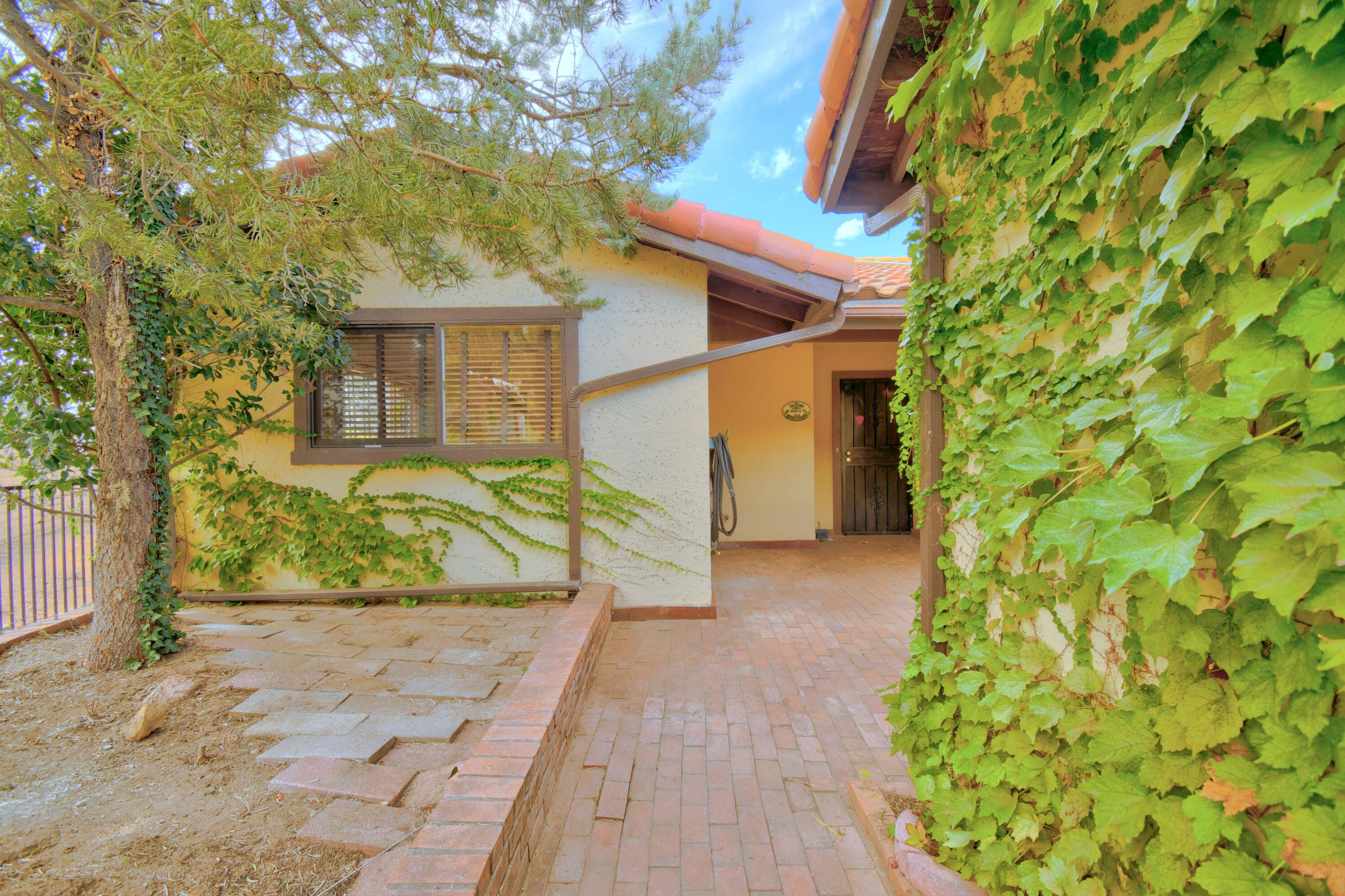 Open house Sunday 10/25 1-3pm. Absolutely darling townhome in highly desirable GLENWOOD HILLS! Nestled on a cul-de-sac and perched above the city, this inviting home offers fabulous city and mountain views. Step inside to light & bright living and dining areas featuring large windows and a cozy fireplace, creating a warm and welcoming atmosphere. The kitchen offers ample counter space and a charming breakfast nook. The spacious primary suite provides plenty of closet space, while the generously sized secondary bedroom is perfect for guests, a home office, or additional living space. Enjoy the private backyard with mature landscaping and raised garden beds--an ideal setting for relaxing, gardening, or entertaining. Solar adds energy-saving potential and extra appeal. Conveniently located near hiking and biking trails, restaurants, shopping, and Kirtland Air Force Base, this delightful home offers the perfect blend of comfort, charm, and location!